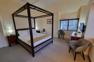 March Madness - Book one night and get another free.... 3 a bedroom with a four poster bed and a desk